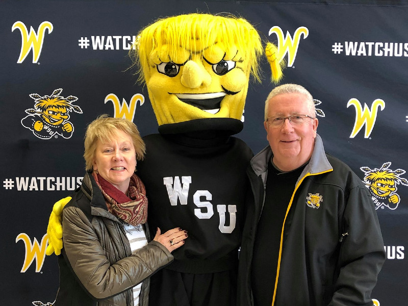 Two alumni members posing with WuShock. 