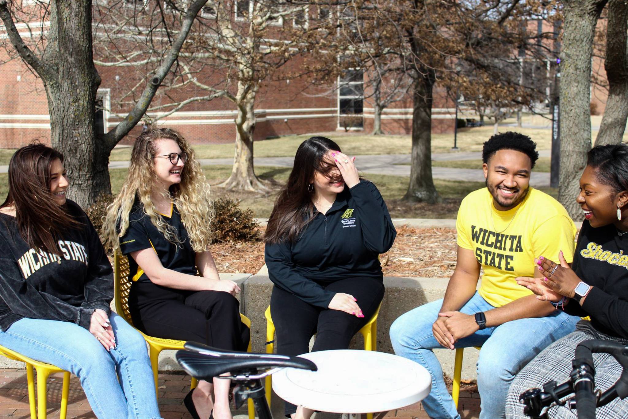 Higher Education Student Affairs students sit outdoors and talk to one another