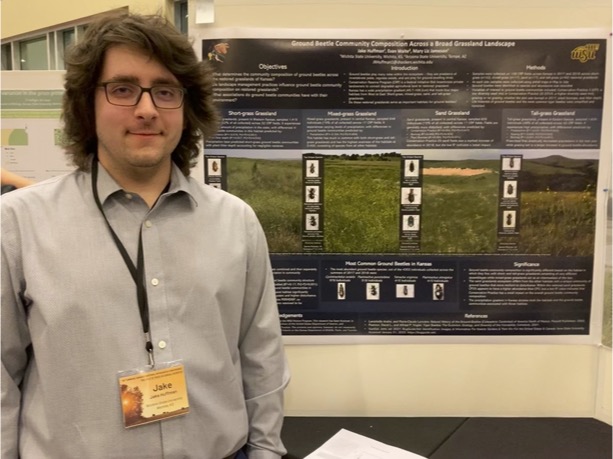 Photograph of a student standing in front of his scientific poster