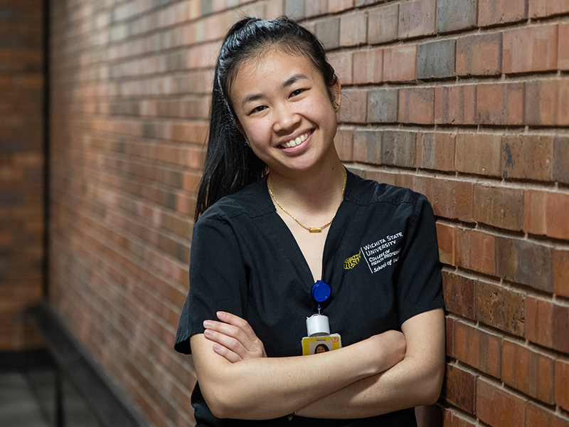 nursing student in scrubs smiling