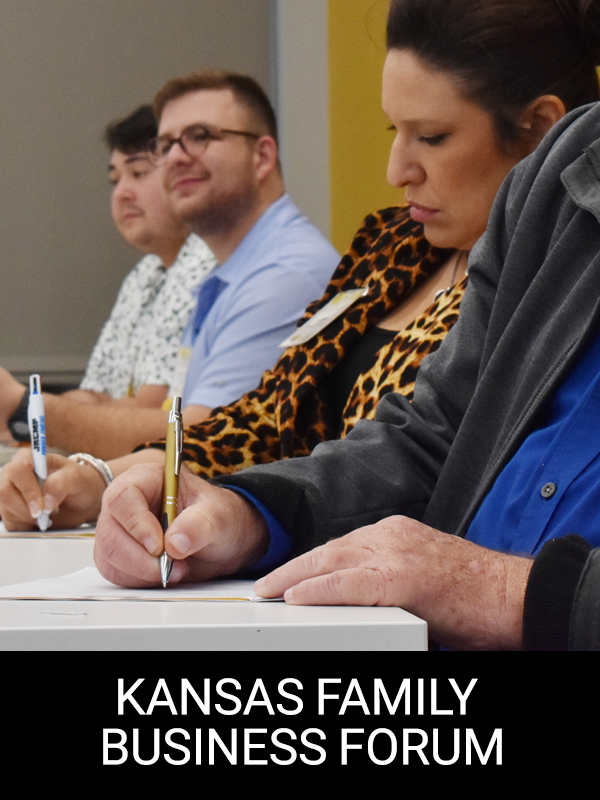 "Kansas Family Business Forum" Family members involved in their business are writing notes from an Executive Breakfast.