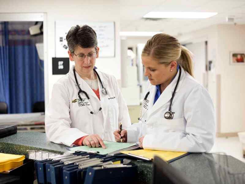 A nursing student meets with their administrator at a nurse station