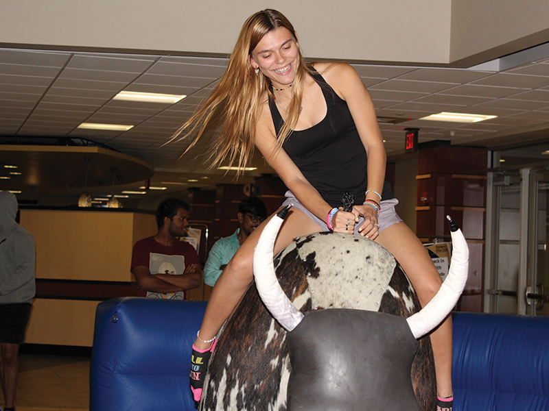Student riding a mechanical bull at Shockers After Dark