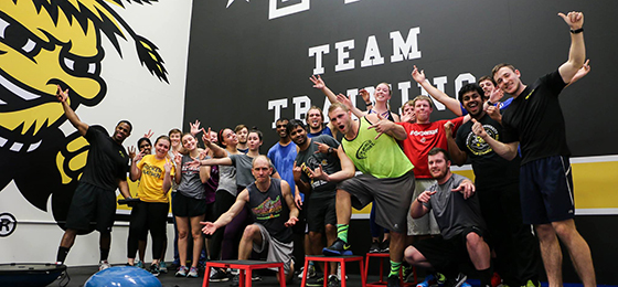 The team of Shocker Fit trainers poses in the F45 room. There is about 30 of them doing fun, outrageous, or aggressive poses.