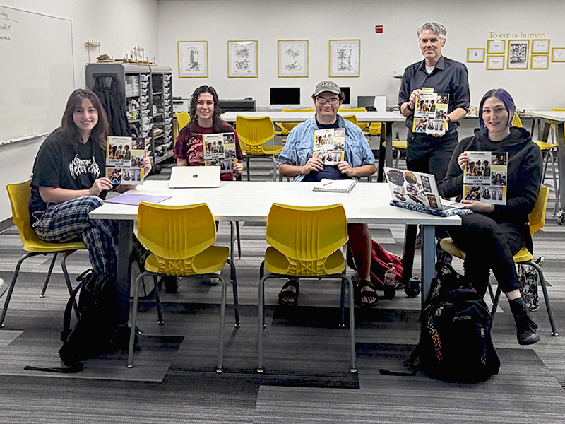 English career seminar students holding their career guide textbooks in class.