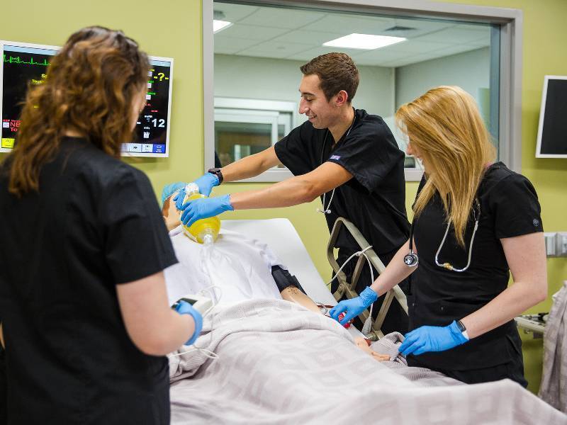 Students work with medical mannequins