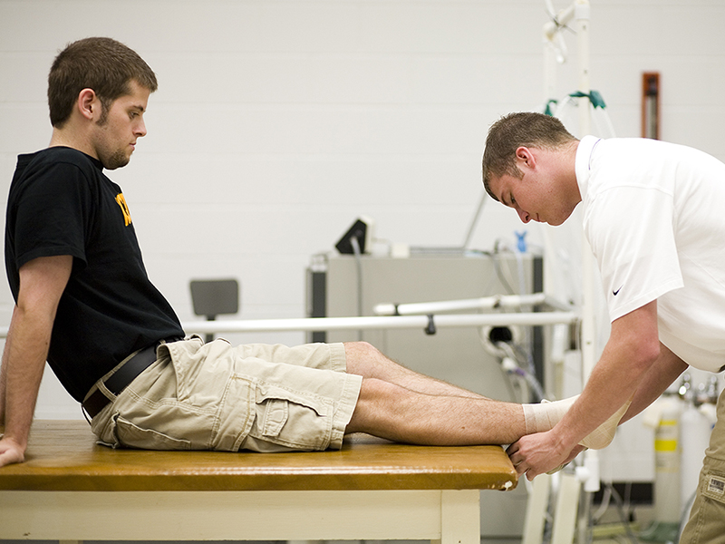  A student from the College of Applied Studies Athletic Training studies an ankle. 