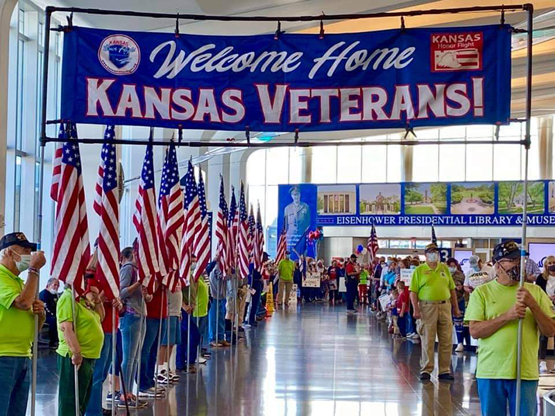 Image of veterans at Eisenhower Airport holding flags.