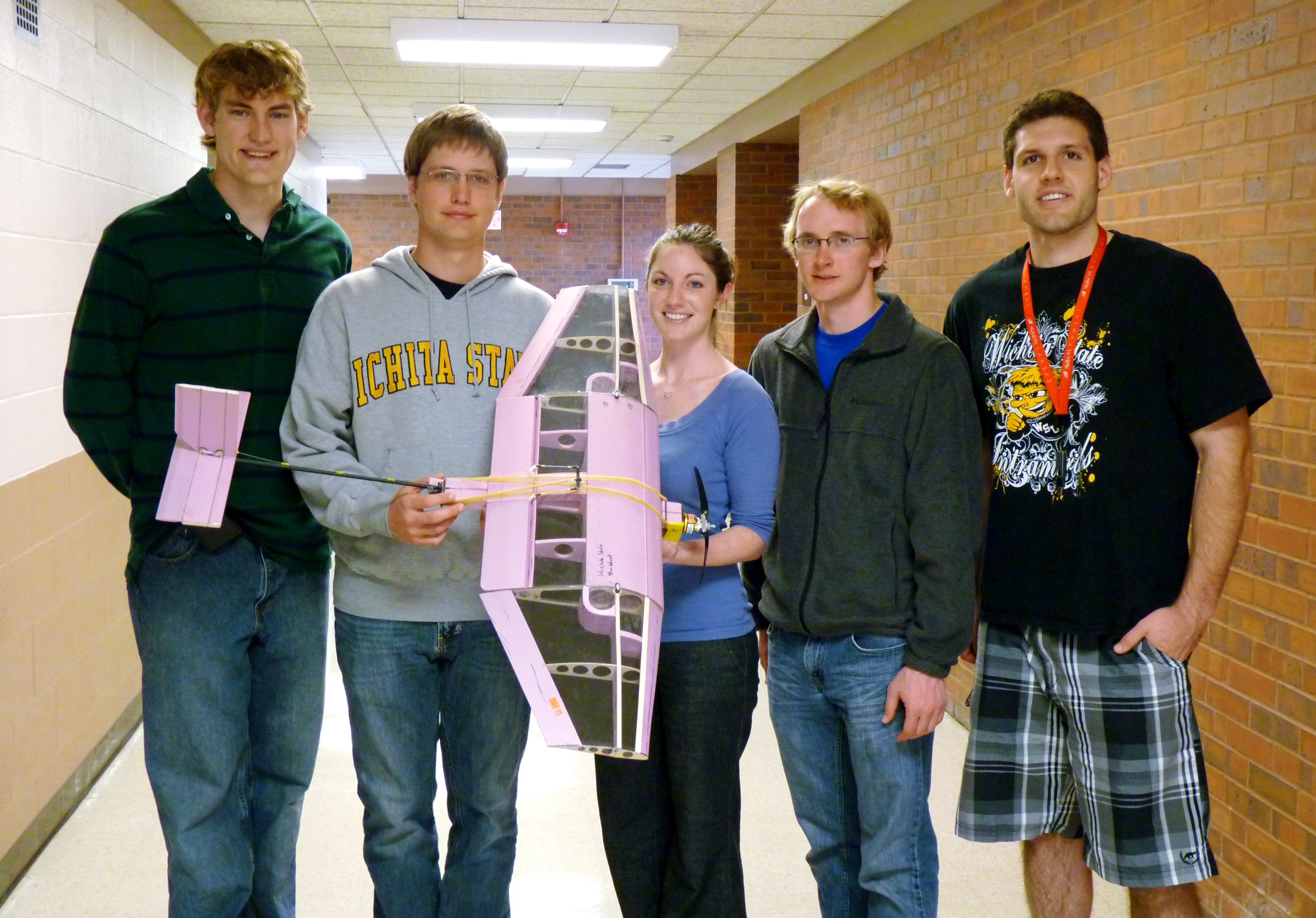 Peter Fast, Allen Herbert, Adrienne Bottom, John Bird and Iwan Broodryk hold the plane that took fourth in the Design/Build/Fly Competition April 15-17 in Tucson, Ariz. With the help of underclassmen, the five seniors battled hot and gusty Arizona conditions to successfully complete three different missions. The team, nicknamed SHARBDU, Shockers Aerial Bag Deployed Unit, worked for more than eight months on the design and testing of the plane.