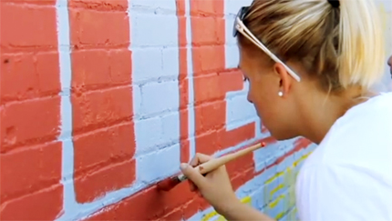 A WSU student helps paint the mural at the Dunbar Theater near downtown Wichita.