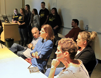 Staff members from University Relations at Wichita State University, foreground, critique a shuttle wrap design by a team of students from WSU's School of Art and Design. This team's design (see below story) was chosen from among four finalists to be used on one of the WSU shuttles.