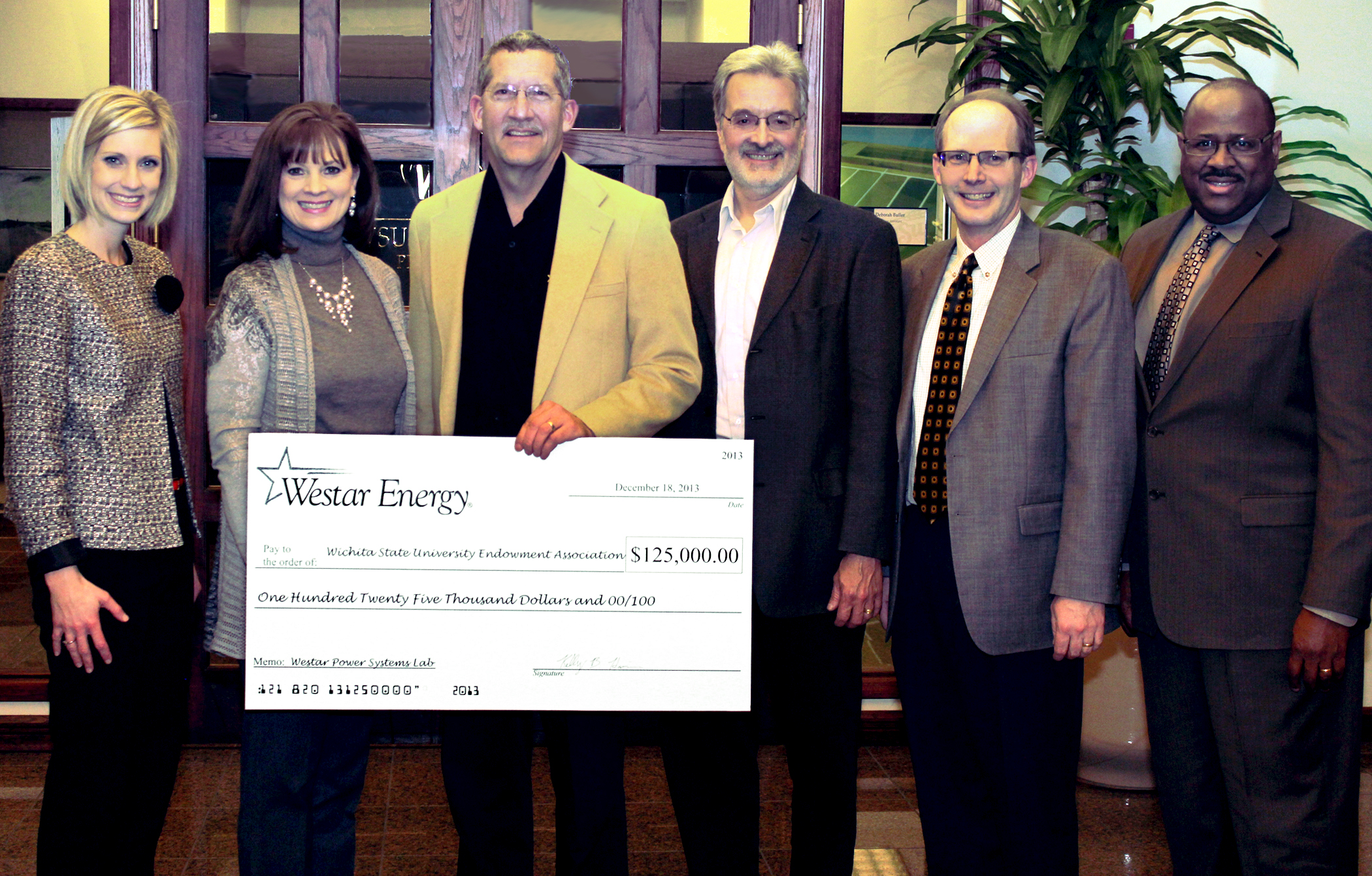 Westar Energy presents a $125,000 oversized check to representatives of WSU and the WSU Foundation to upgrade a power systems lab.