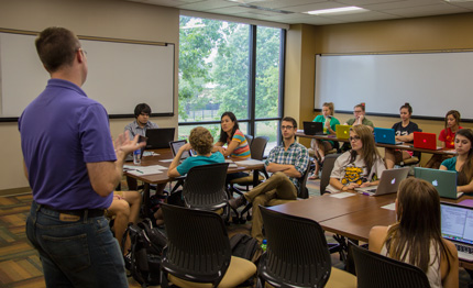 Instructor Eric Wilson and his Public Information Writing class enjoy Elliott Hall's new flexible learning space, one of many changes made at the Elliott School over the summer.