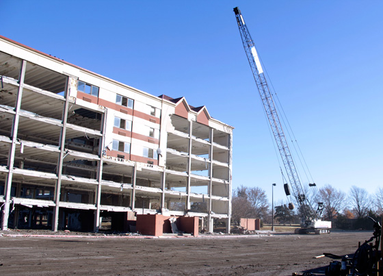 A crane swings a wrecking ball at the remnants of Wheatshocker Apartments.  The building is being razed to make room for a new Experiential Engineering Building.