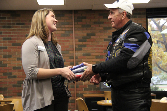 Sarah Sell, Director of Veteran Student Services at Wichita State, accepts a donation of military flags to decorate WSU's Military and Veteran Student Center. The center, established in 2013, is one of the initiatives that helps makes WSU a military-friendly campus.