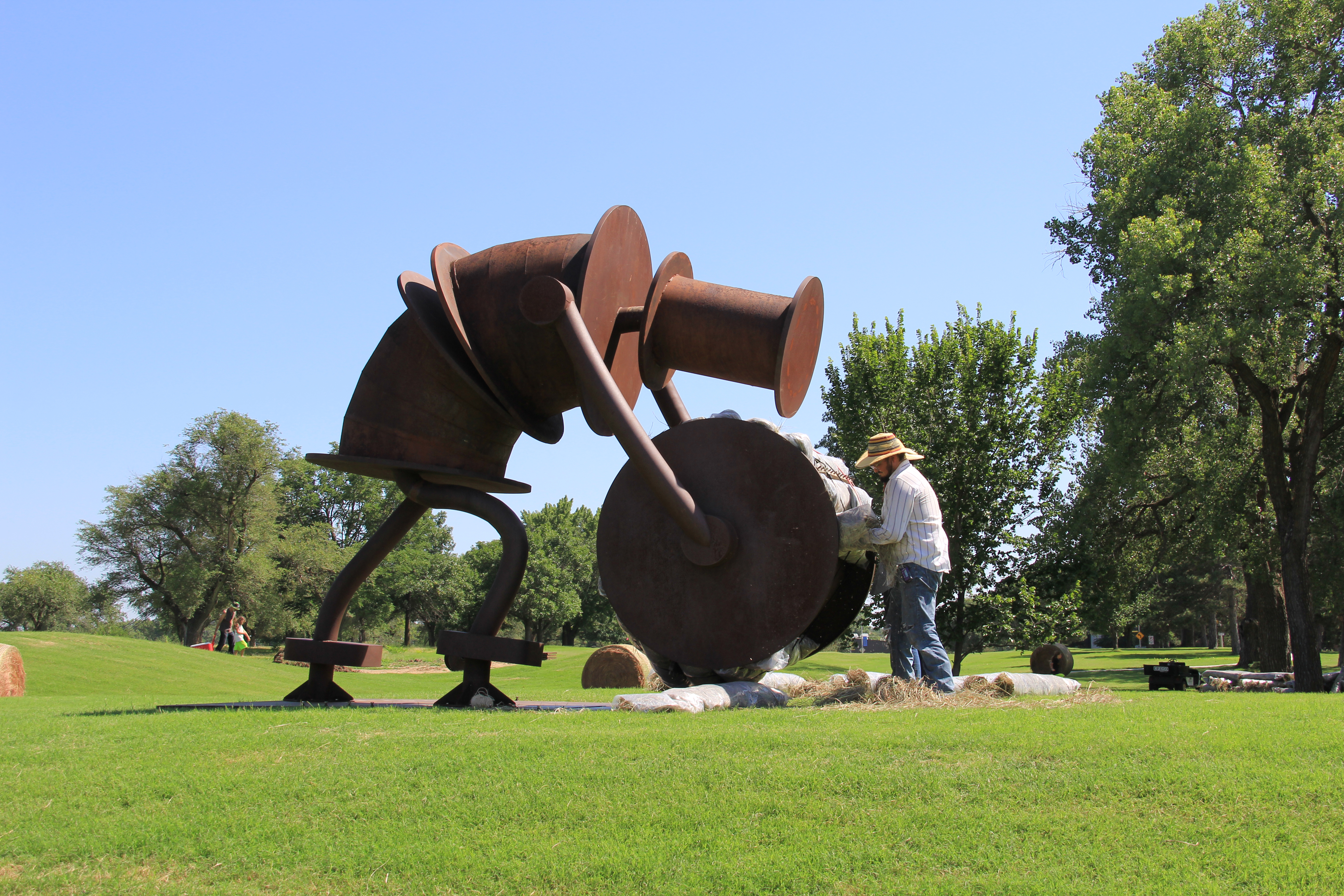 A worker installing the Tom Otterness sculpture &quot;Makin' Hay&quot; on the Innovation Campus. The piece will be publicly unveiled in a ceremony Aug. 27.