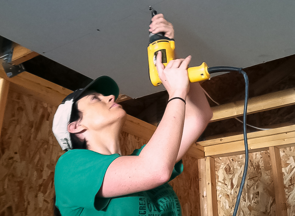 Students hung drywall and painted while volunteering for Habitat for Humanity, learning more about the company their class will create a promotional plan for.