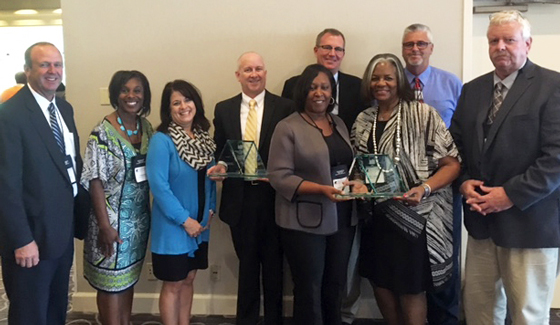 Accepting the Shirley S. Schwartz award are (back row from left) Bill Faflick, Assistant Superintendent of Secondary Schools, Tiffinie Irving, Executive Director of Instructional Support, Ashlie Jack, Assistant Dean WSU College of Education, Clay Stoldt, Associate Dean WSU College of Education, John Allison, Superintendent Wichita Public Schools, Jeff Davis, Wichita Board of Education, Mike Rodee, Wichita Board of Education. (Front row from left) Alicia Thompson, Assistant Superintendent of Elem