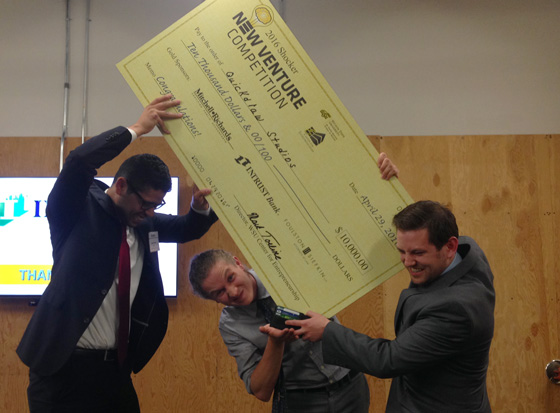 From left: Wichita State students Nicolas Gallo, Brian Foster and Cody Harryman try to fit their over-sized $10,000 check into a wallet. The trio won first place in the Shocker New Venture Competition for their business, Quickdraw.