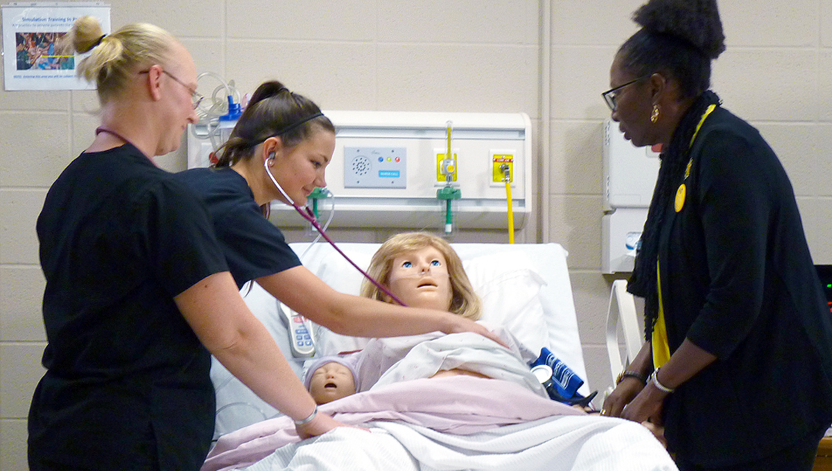 Wichita State Health Professions Dean Sandra Bibb, along with fourth-semester nursing students Rebecca Angell and Margaret Hughes, train with the new simulation mannequins.