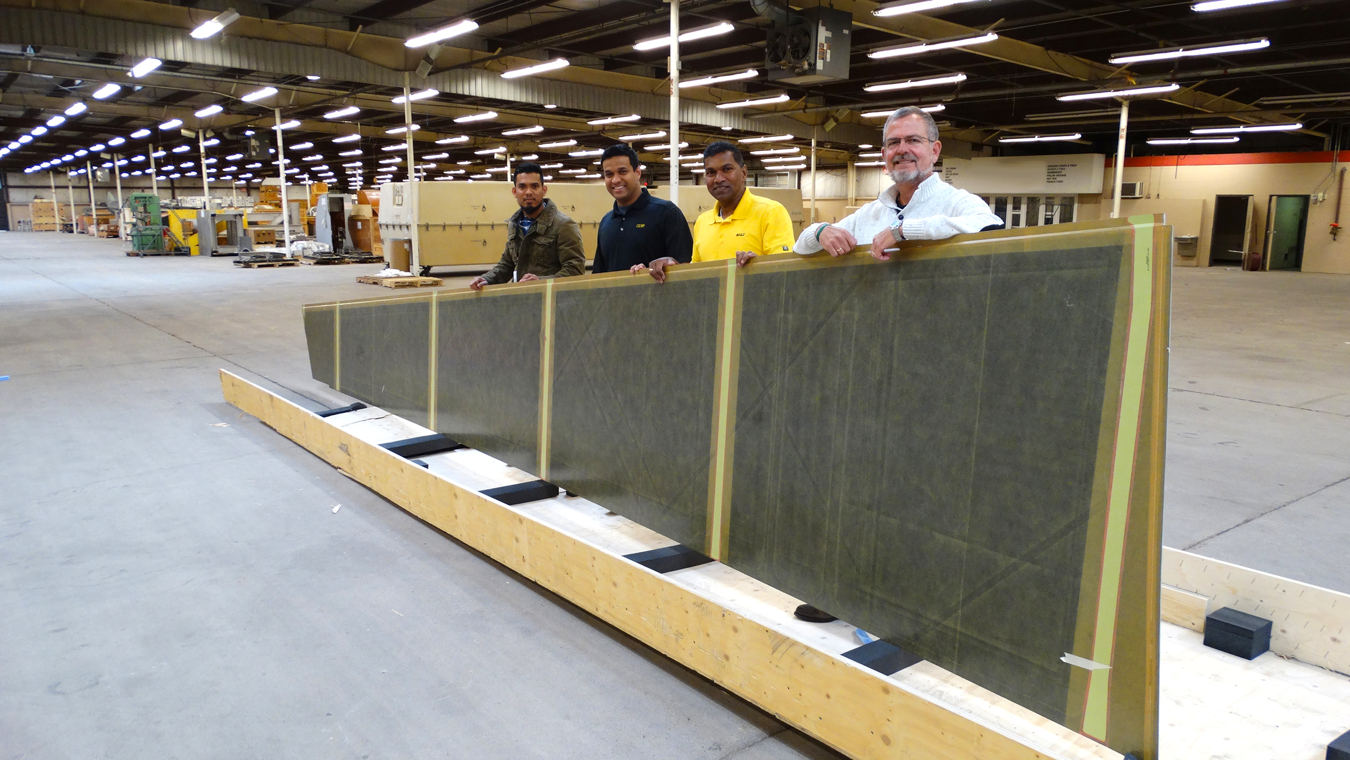 NIAR research engineers Supun Kariyawasam, Upul Palliyaguru and Waruna Seneviratne and Airbus employee James Werbin display an Airbus A300 part donated for NIAR research.