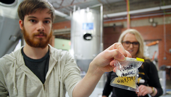 As a new intern at a local brewery, Wichita State student Alex Zeorlin is learning the finer points of lab testing beer from fellow student Alexandrea Feldkamp, WSU's first intern at Wichita Brewing Co.