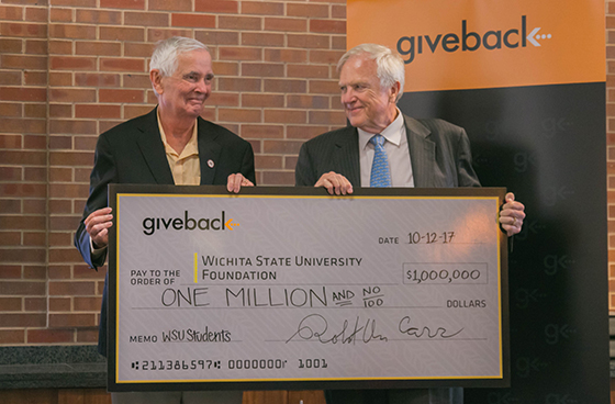 Wichita State University President John Bardo, left, accepts a $1 million check from Give Something Back Founder Robert Carr. The Give Back program will provide full-ride scholarships to 50 underserved students.