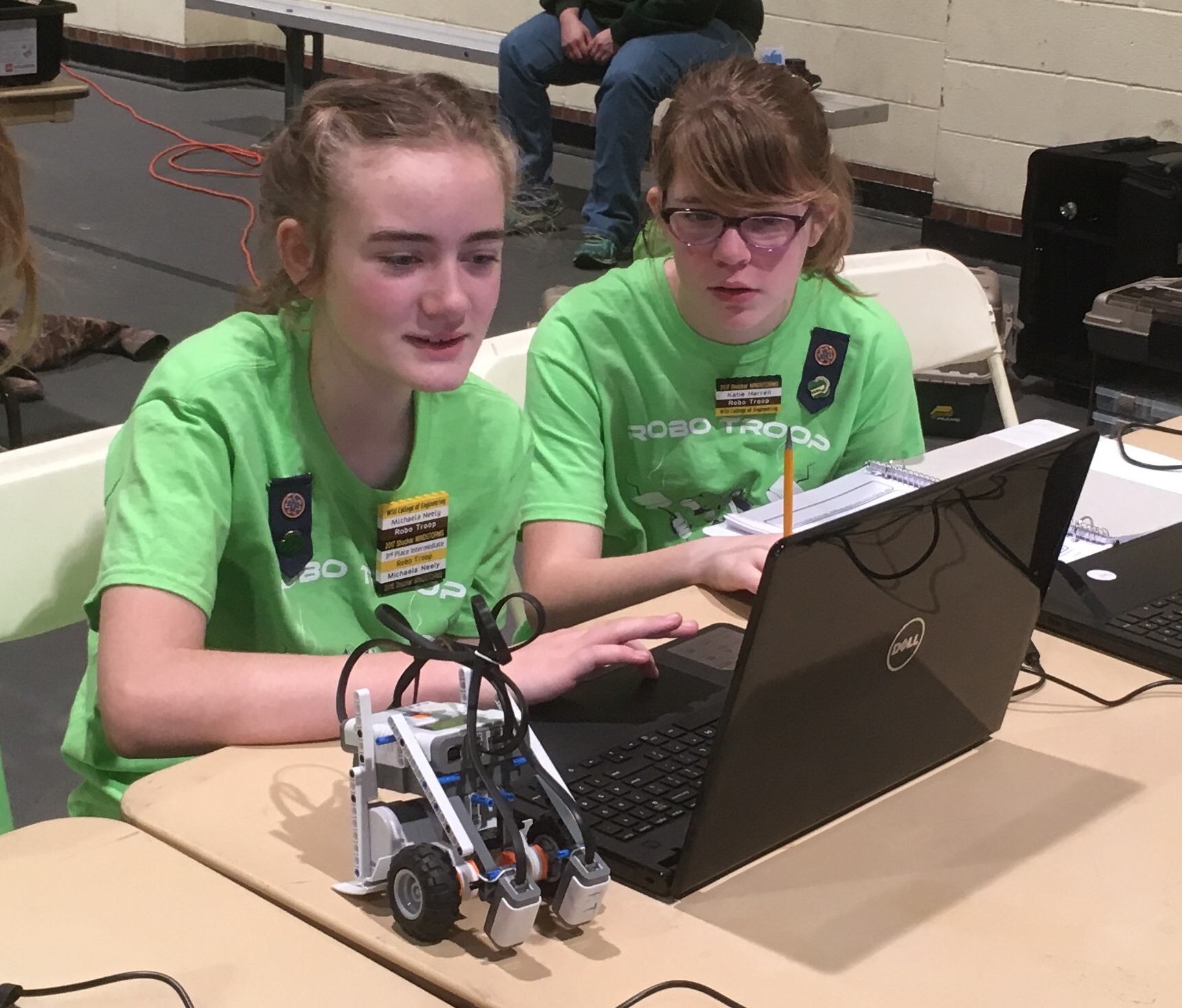 Members of the Girls Scouts of the Kansas Heartland's Robo Troop MINDSTORMS team modify the program on their LEGO robot between competition runs during the 2017 challenge.