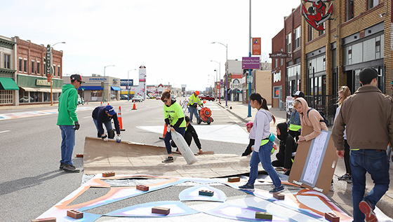 Students and the Wichita community work together to add a vibrant street mural to the Douglas Design District.