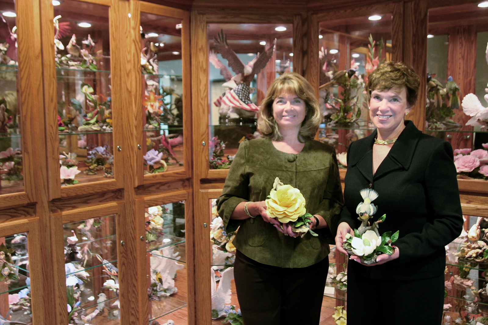 Carole Lindley, left, and Nacy Martin post in front of the Boehm sculpture collection, part of which was donated to Wichita State.