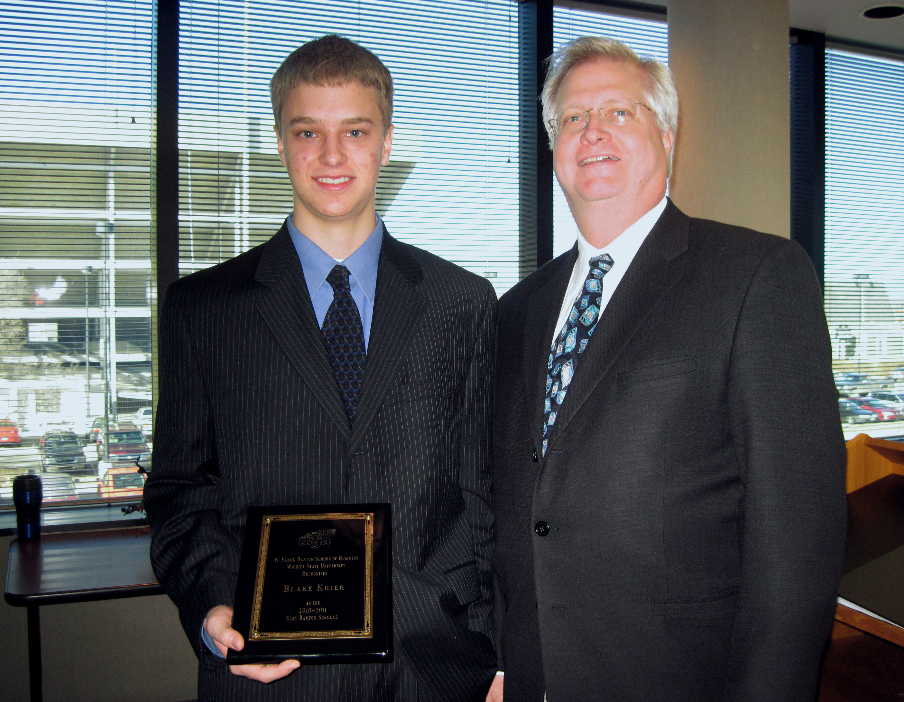 Blake Krier, left, poses for a photograph with Craig Barton, brother of the late Clay Barton, for whom the scholarship is named after.