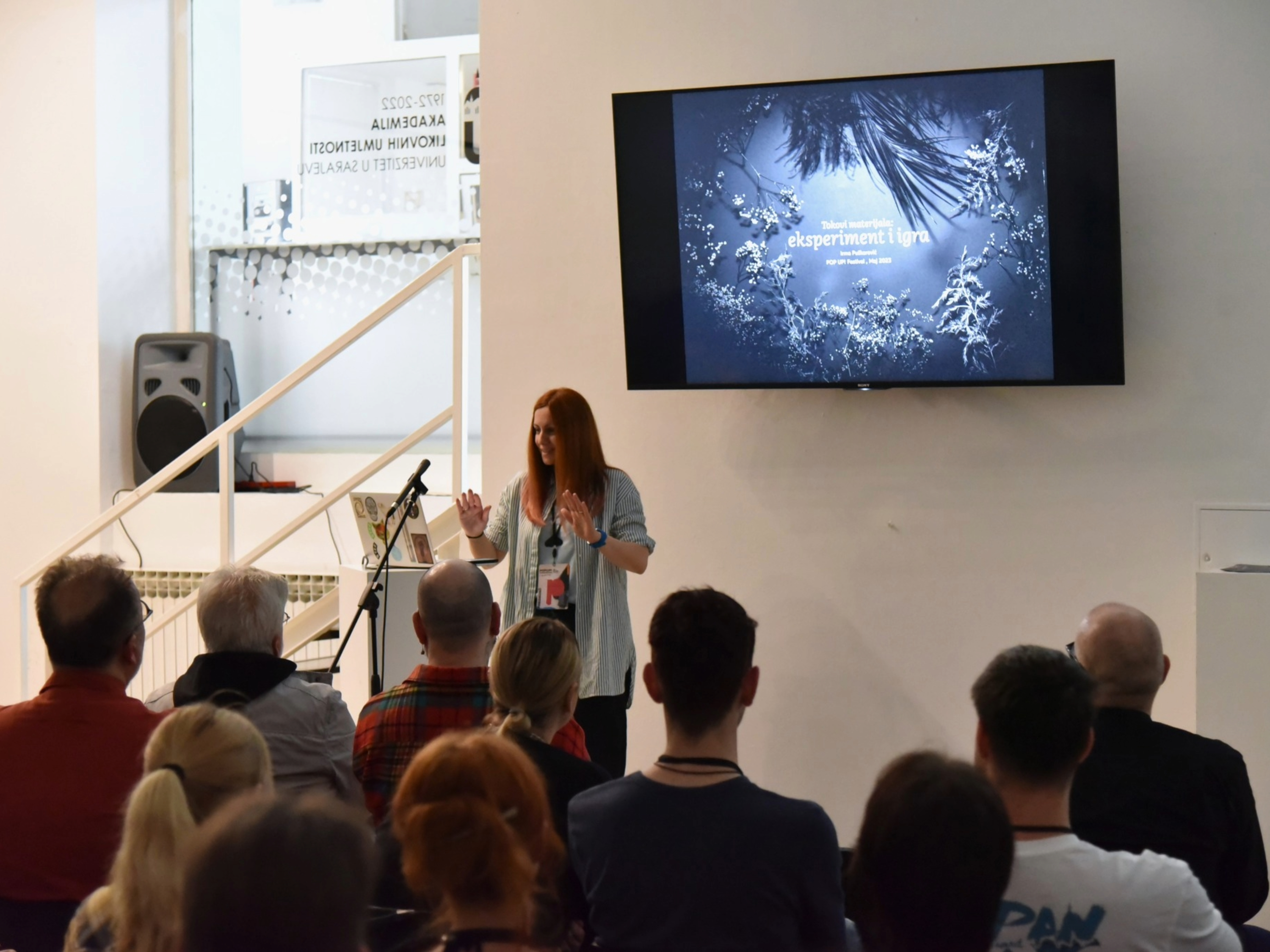 Dr. Irma Puškarević presents at the Pop Up! Design Festival in Sarajevo, Bosnia and Herzegovina, speaking to an audience in front of a projected slide titled “eksperiment i igra.”