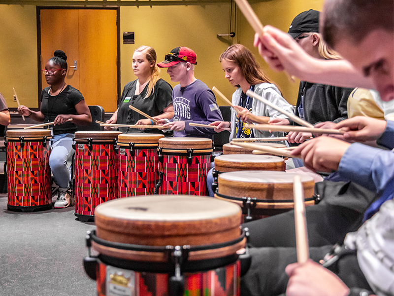 Students use drums during a performing arts class. 