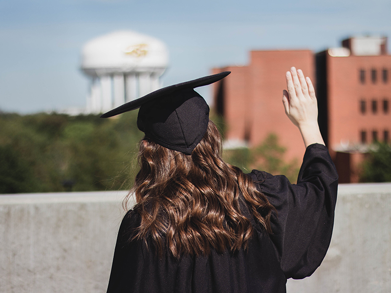Maddie Harris waves goodbye to campus as she graduates