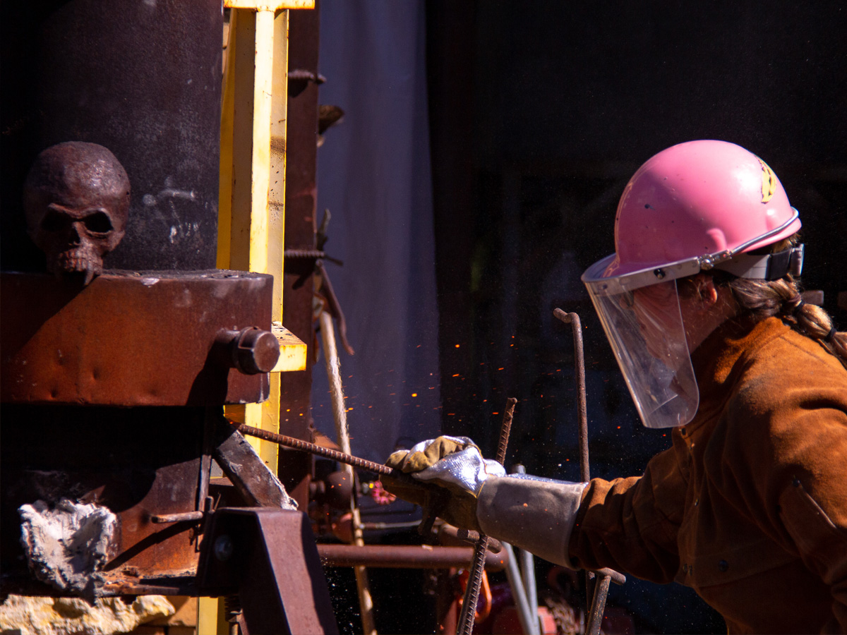 An ADCI faculty mixes molten iron in a crucible during WSU's 2019 Open House.