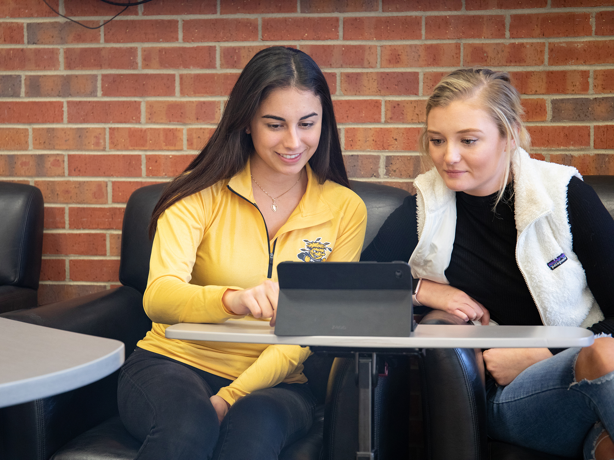 Two Wichita State students using a tablet.