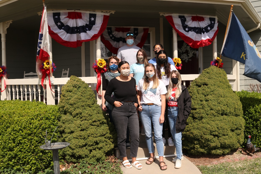 Students standing in front of a decorated porch