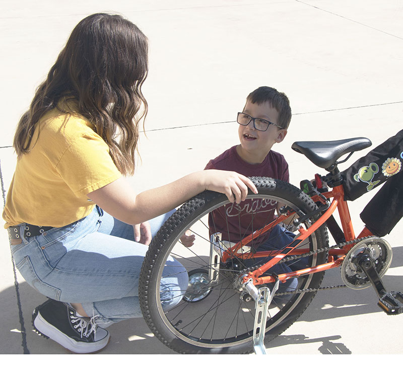 Ford Hall speaks with Adrianna Gutierrez, Wichita State University civil engineering technology junior.  Gutierrez, is one of seven WSU students who modified a bicycle to meet Ford's needs.