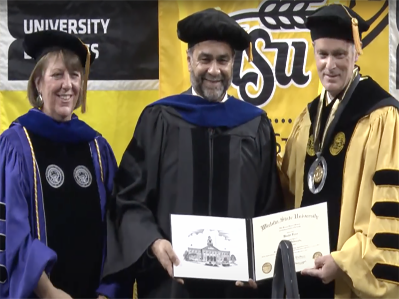 Shirley LeFever and President Muma hand Khalid Raza an honorary degree at the WSU fall 2021 Commencement.