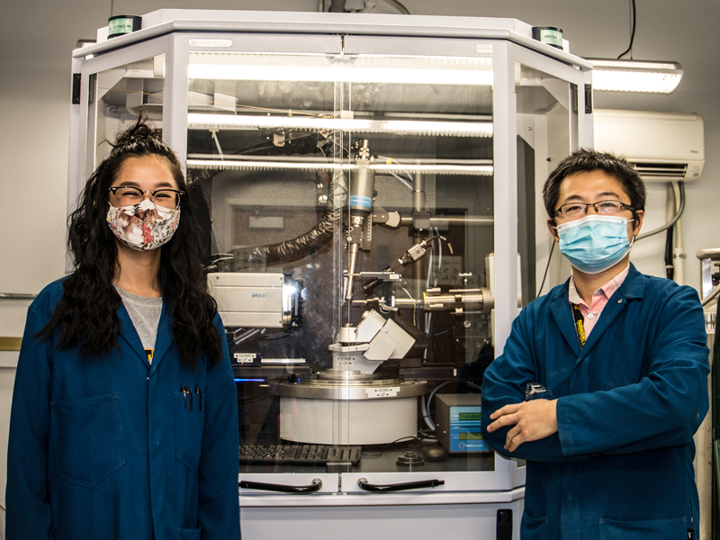 Vivian and Jian stand in front of the crystal X-ray diffractometer to visualize the atoms. 