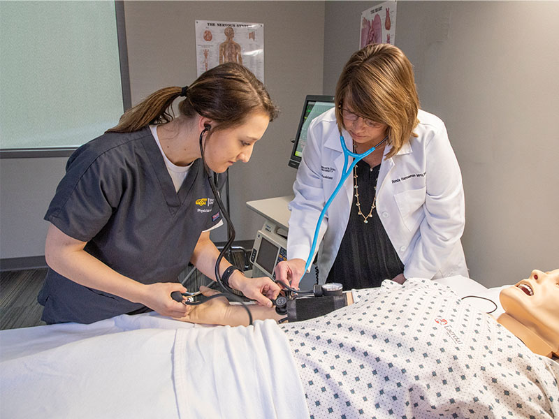 Physician Assistant student works on manikin with faculty member