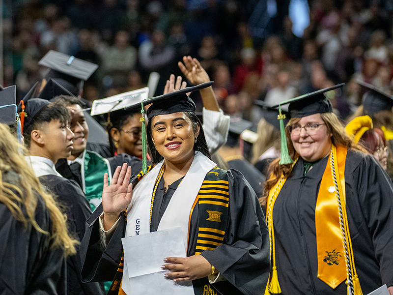 A Wichita State graduate smiles at the camera.