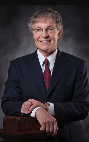 A Wichita State graduate smiles at the camera.