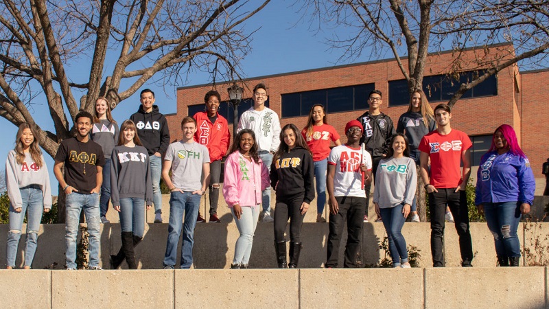 Fraternity and Sorority Life representatives pose in front of Ablah Library