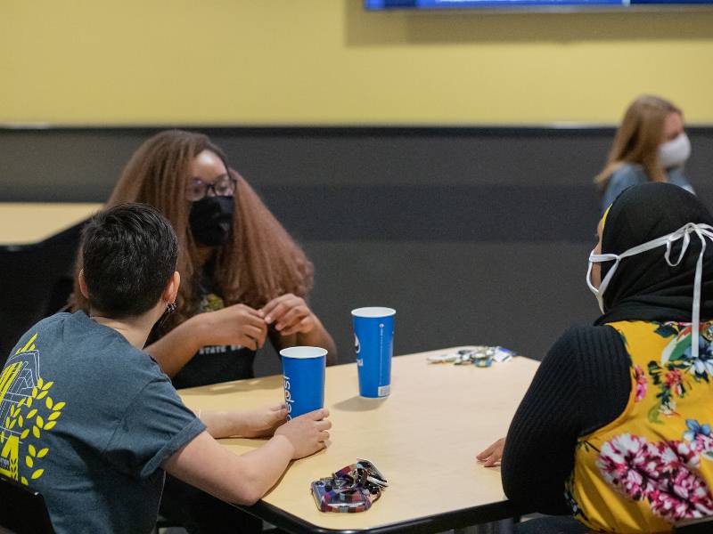 Students dining together with masks on