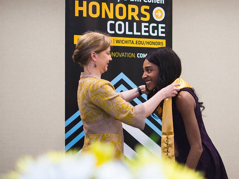 Honors College Dean Engber awards a student their honors stole for graduation