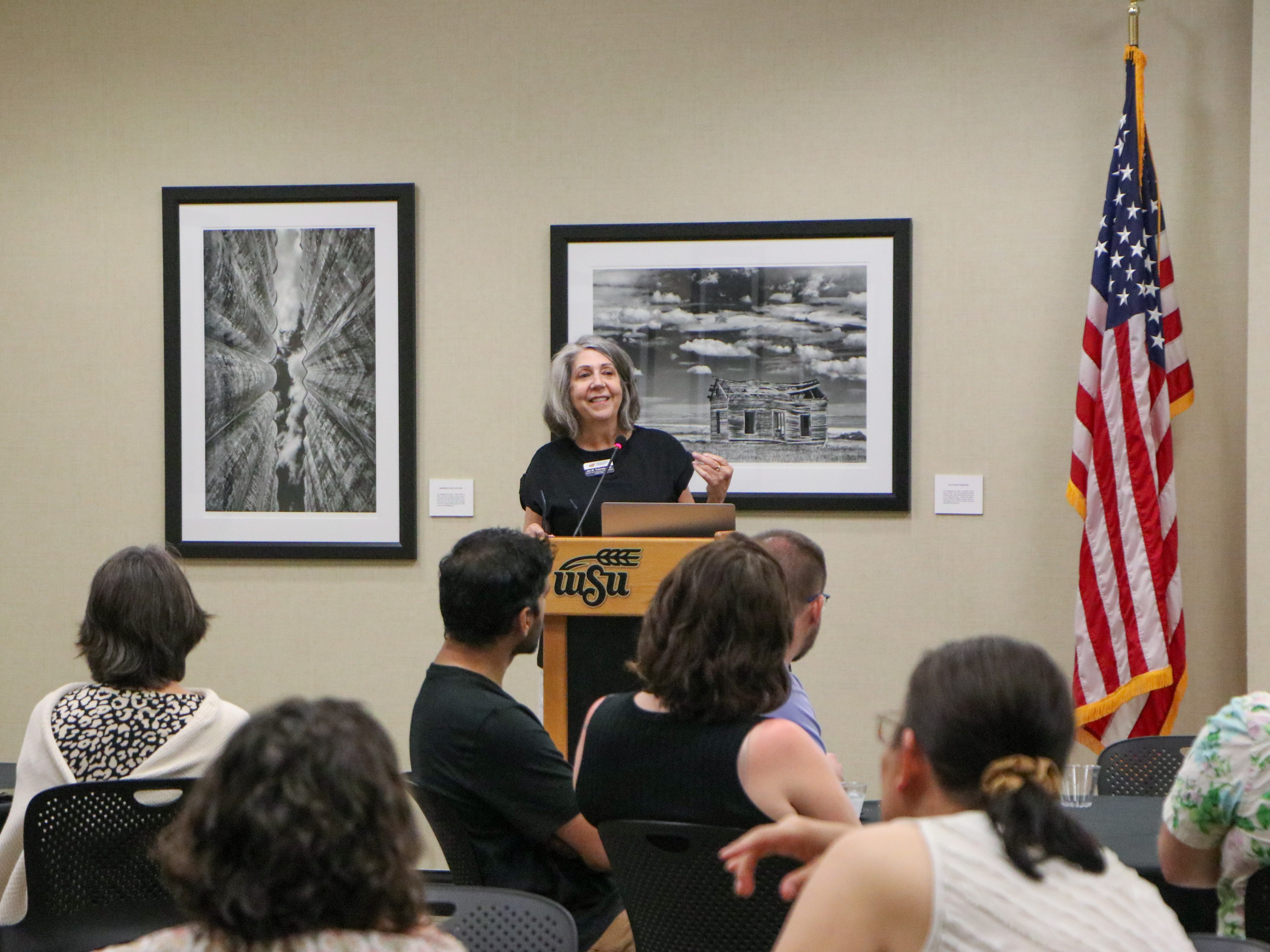 Three faculty members stand at the front of an awards ceremony to explain their neuroimaging Mutual Mentoring project.