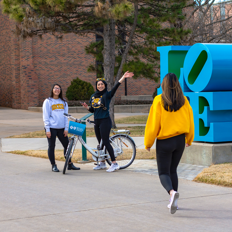 girls with bikes on campus