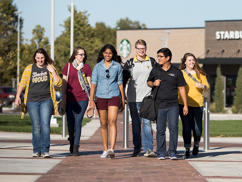 A group of students walk by the Starbucks in Braeburn Square on the Innovation Campus at Wichita State