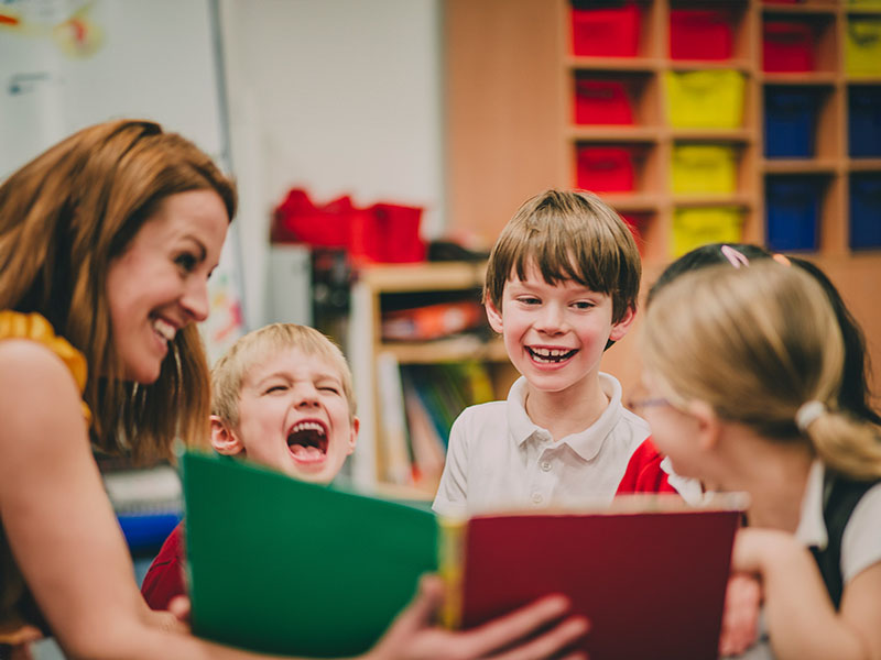 A para reads with a small group of children